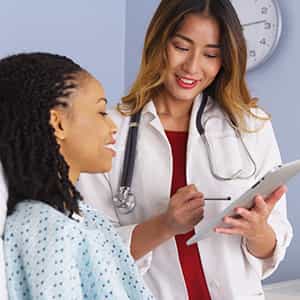 Asian_Female_Doctor_With_BlackFemale_Patient_Depositphotos_222824462_300x300_Q50 Asian Female Doctor With Black Female Patient